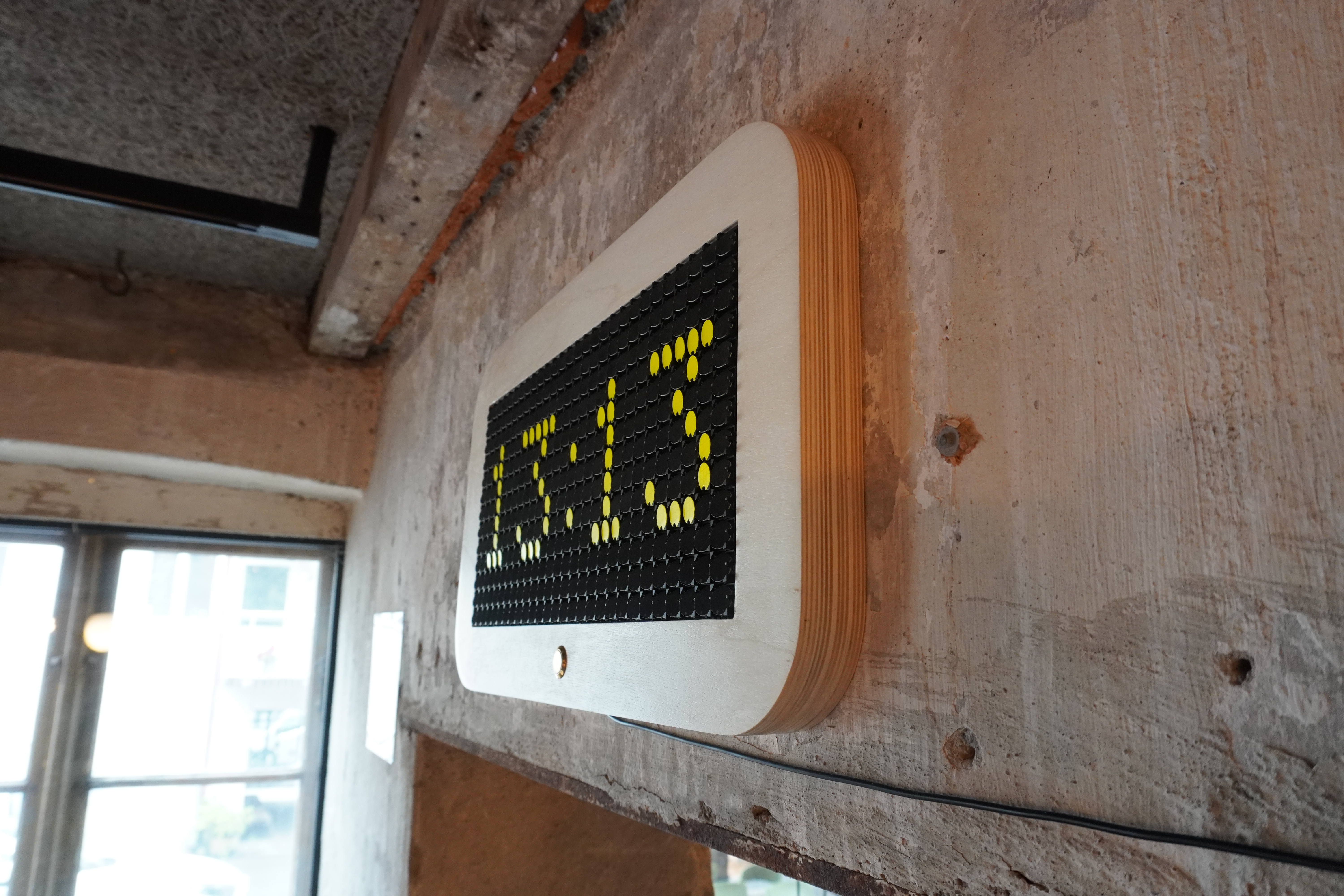 Oblique view of the flip-dot clock on the wall